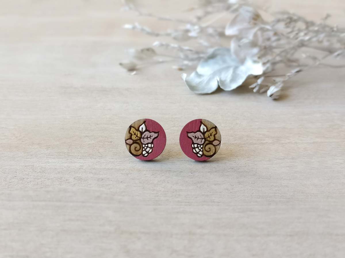 colorful wooden earrings in pink color mini round on background