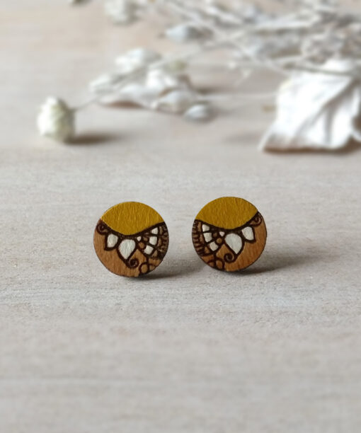 handcrafted wooden earrings in ochre color mini round on background