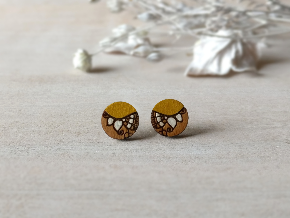 handcrafted wooden earrings in ochre color mini round on background