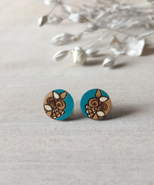 handmade wooden earrings in turquoise color mini round on background