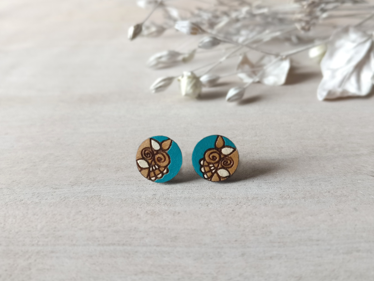 handmade wooden earrings in turquoise color mini round on background