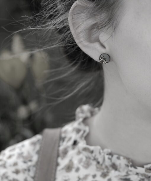 mini round wooden earrings rose design on model