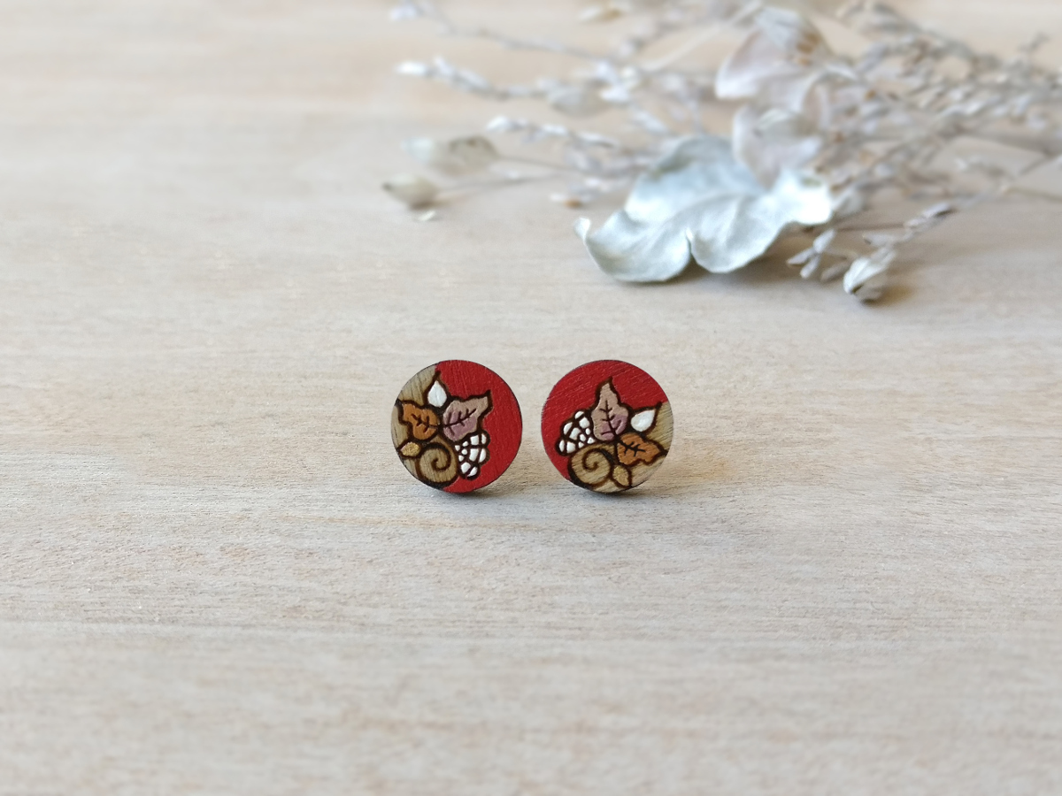 red wooden earrings in red color mini round on background
