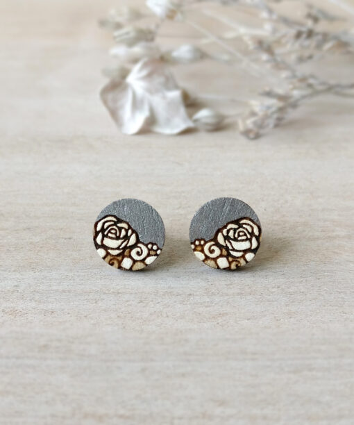 stylish wooden earrings in silver color mini round on background