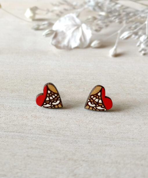 colorful wooden heart earrings in red color on background