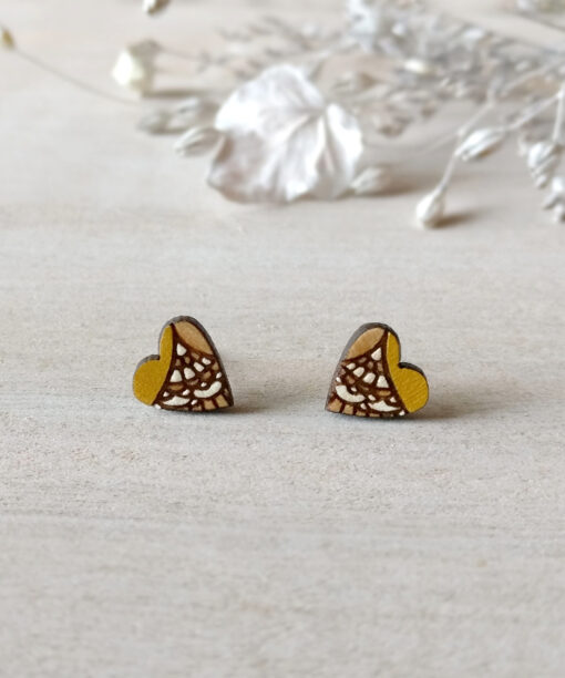 handcrafted wooden heart earrings in ochre color on background