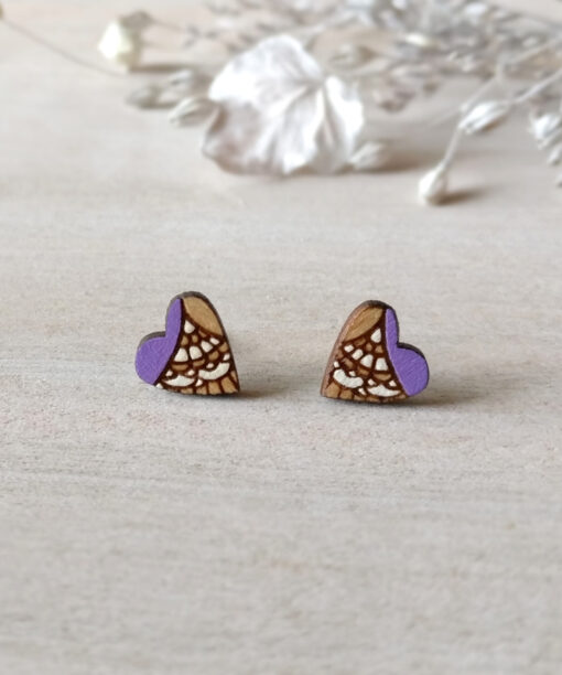 stylish wooden heart studs in light purple color on background