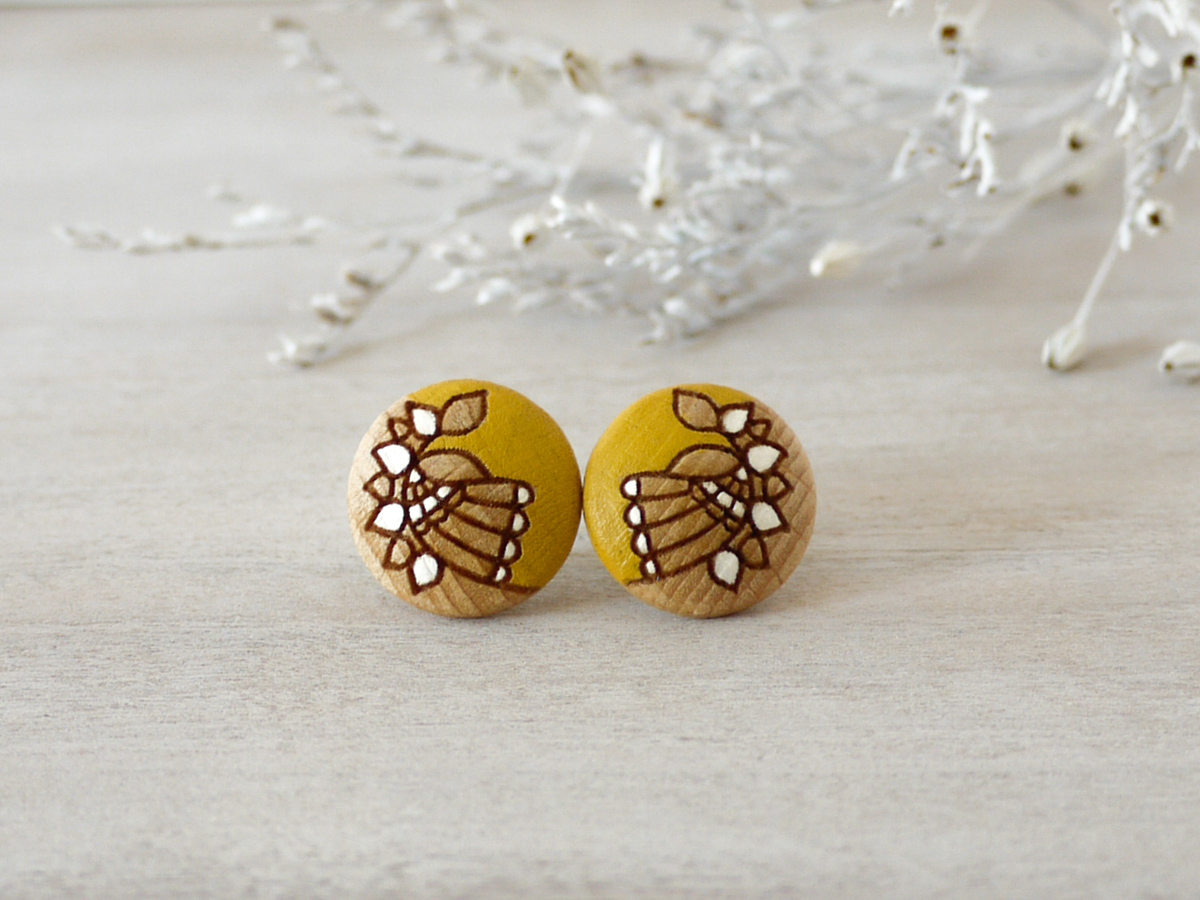 medium yellow wooden earrings on background
