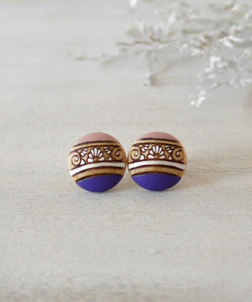 detailed wooden earrings in purple color small on background