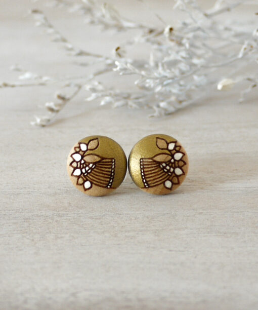 small gold wooden earrings on background
