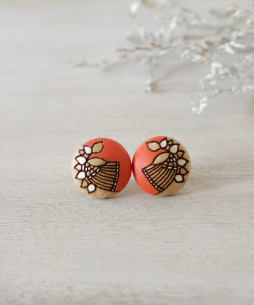 small orange wooden earrings on background