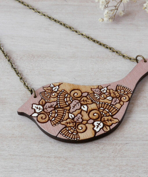 bird rose gold wooden necklace on background