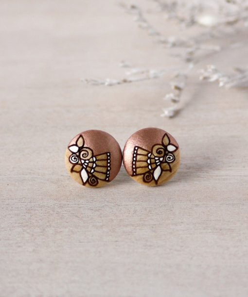 small wooden earrings in rose gold color on background