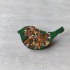 bird green wooden brooch on background