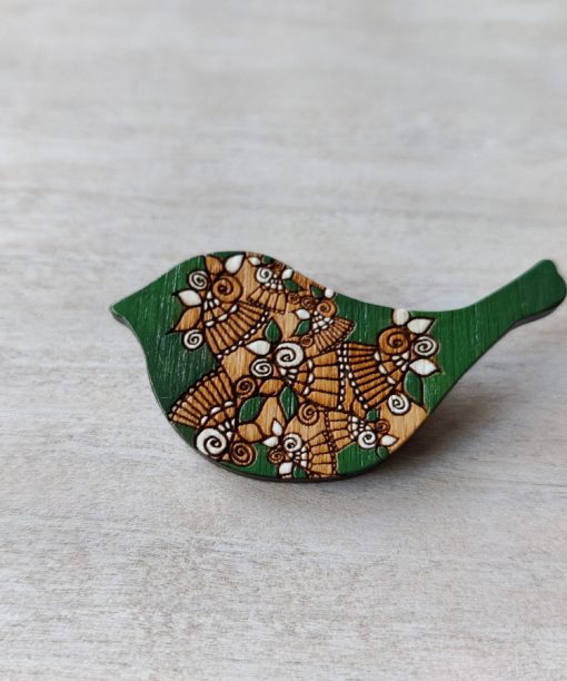 bird green wooden brooch on background