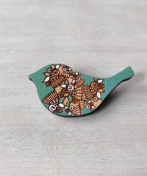 bird mint wooden brooch on background