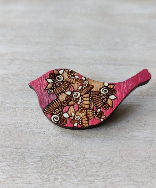 bird pink wooden brooch on background