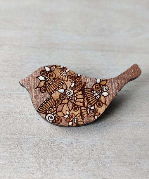bird rose gold wooden brooch on background